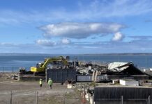 Contractors demolish big, blue 100-year-old freight shed at the Kingscote jetty